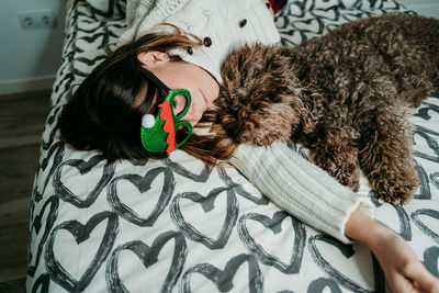 Young woman relaxing with dog on bed at home