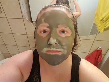 Close-up portrait of a young woman in bathroom
