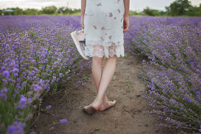 Low section of woman standing on field