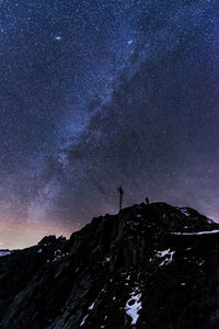 Low angle view of silhouette mountain against sky at night