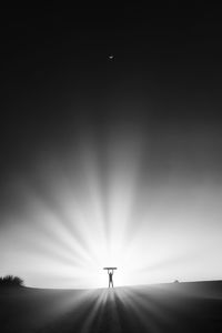 Silhouette person standing on field against sky