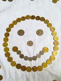 Close-up high angle view of coins resembling smiley emoticon. 