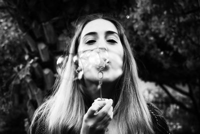 Portrait of young woman smoking cigarette outdoors