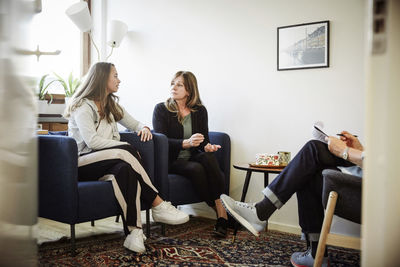 Daughter arguing with her mother during therapy session at workshop