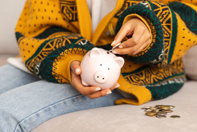 Midsection of man holding piggy bank