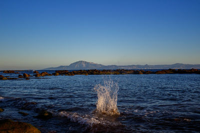 Scenic view of sea against clear blue sky