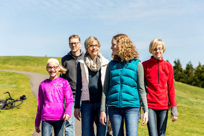 Friends standing on grassy field