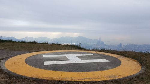 Helicopter landing pad on road against sky and hongkong in backround