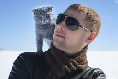 Portrait of man wearing sunglasses standing against clear sky