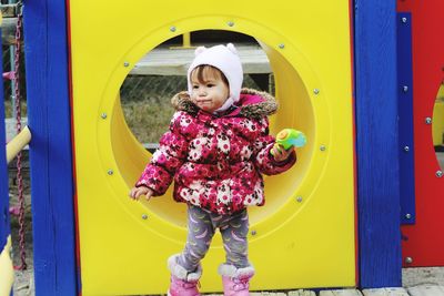 Cute girl looking away while standing in playground