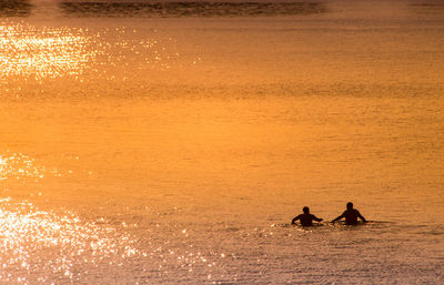 Couple bathing in the sea in les sables d'olonne at sunset