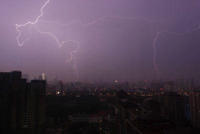 Aerial view of illuminated cityscape against sky at night