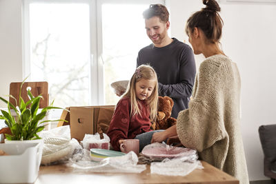 Side view of family sitting on table at home