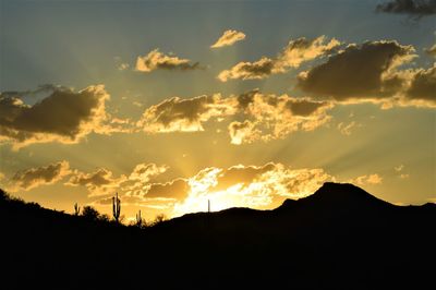Low angle view of silhouette mountain against dramatic sky