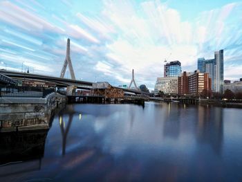 Bridge over river in city against sky