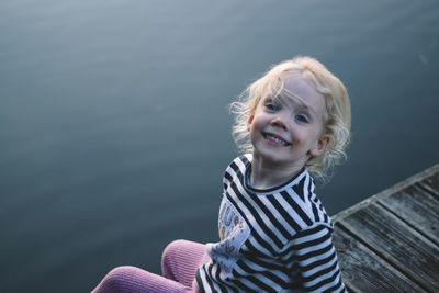 Portrait of smiling boy against water