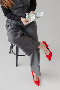 Low section of woman holding gift box against white background