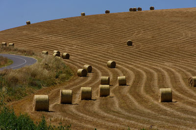 High angle view of hay bales on field against sky