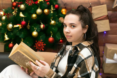 Young woman holding christmas tree