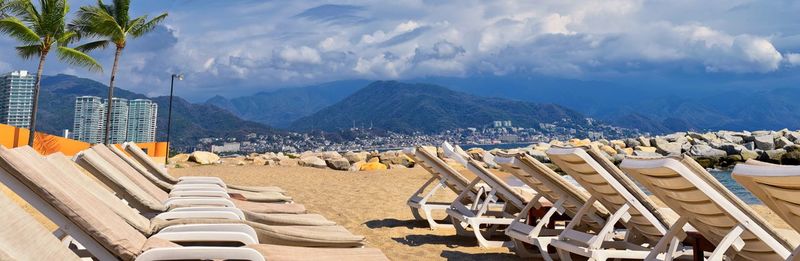 Beach, city and ocean view in puerto vallarta mexico with beach chairs and coastline.