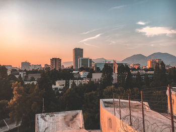 Buildings in city against sky during sunset