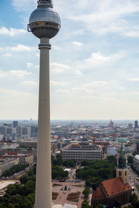 Low angle view of fernsehturm tower against cloudy sky in city