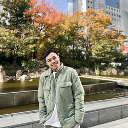 Portrait of young man standing against building