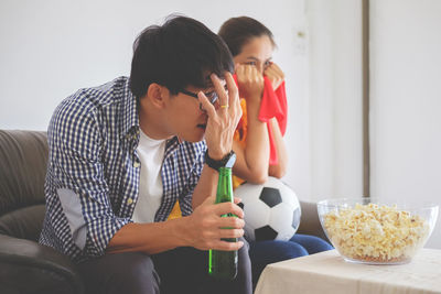 Cheerful friends enjoying soccer match at home