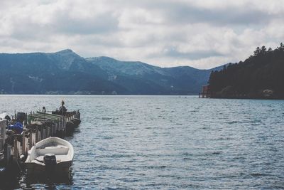 Scenic view of lake by mountains against sky