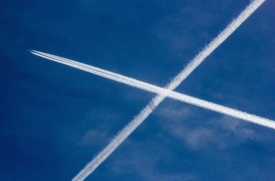 Low angle view of airplane flying against blue sky