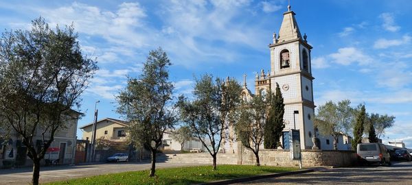 Low angle view of trees and buildings against sky