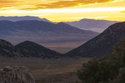 Scenic view of mountains against orange sky