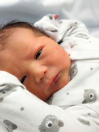 Portrait of cute baby lying on bed