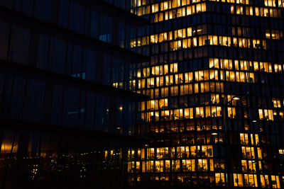 Office building exterior with glowing lights in windows at night city. vienna city downtown