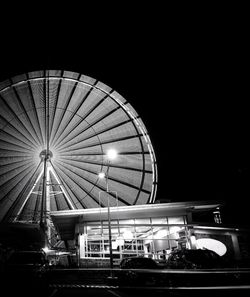 Low angle view of illuminated ferris wheel against sky at night