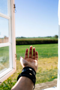 Human hand sticking out of the window.