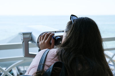 Woman looks through binoculars at the sea. traveler vacation holiday concept. new travel destination