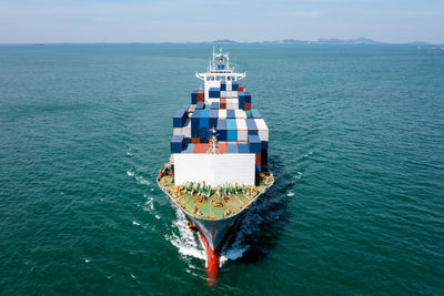 Container cargo ship carrying commercial container in import export business services commerce 