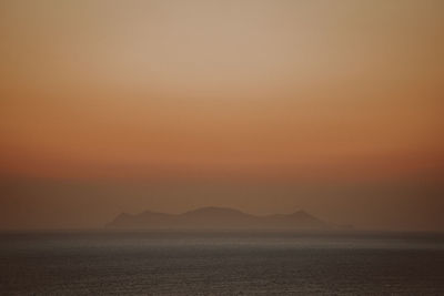 Scenic view of sea against orange sky