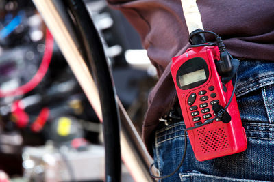 Midsection of man with red radio