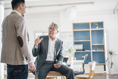 Senior businessman talking to young businessman in office