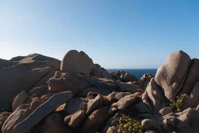 Rocks on beach against clear sky