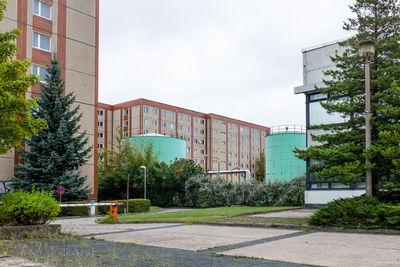 Road by buildings against sky in city