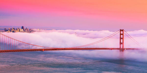 Suspension golden gate bridge over sea against cloudy sky