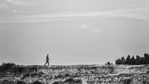 Man standing on field against sky