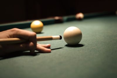 Close-up of person playing pool on table