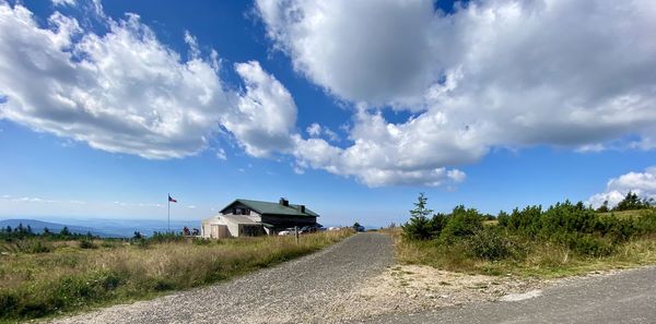 Road amidst field against sky