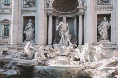 Statue of fountain in front of historical building