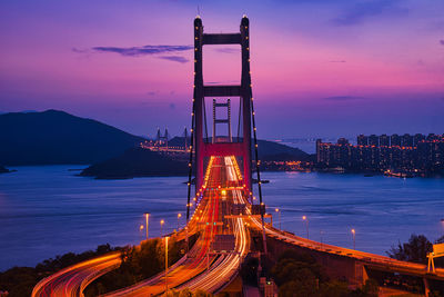 Illuminated bridge over ocean channel against sky at night