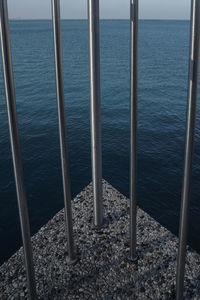 High angle view of metal railing by sea
